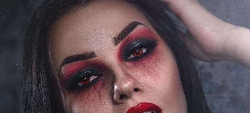 mulher em cosplay vampiresco com lentes de contacto vermelhas halloween